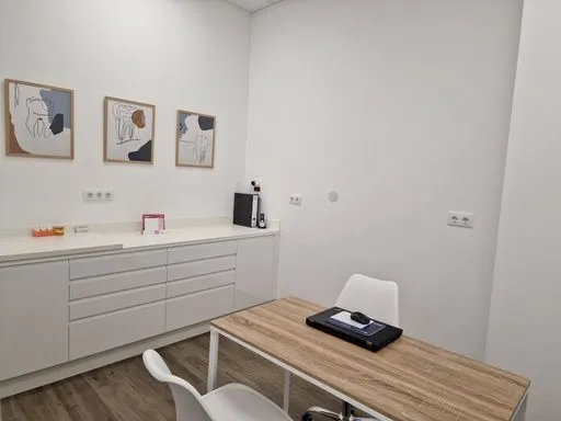 Despacho de consulta de Diseña Dental en Vigo con mesa y láminas decorativas